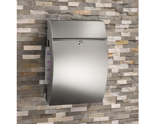 Stalen brievenbus aan een stenen muur