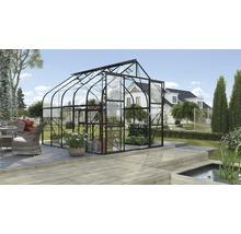Een serre met glazen wanden en een donker frame staat in de tuin.
