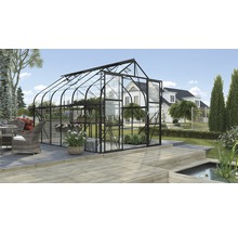 Kas met glas en metalen frame in de tuin