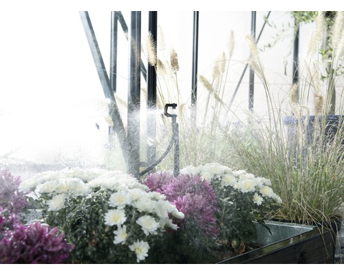 Irrigatiesysteem met sproeier tussen planten en grassen