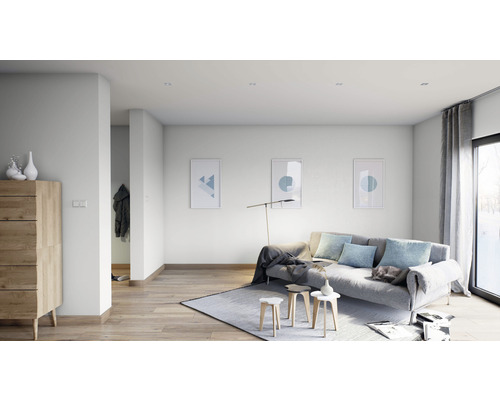 Lichte woonkamer met bank, vloerkleed, houten dressoir en wanddecoratie.