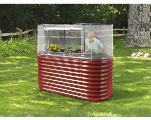 Metalen verhoogde tuinbak met broeikasopzetstuk in de tuin met kind
