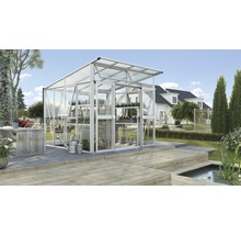 Glazen en aluminium kas met plantenplanken in een tuin