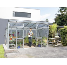 Kas met planten en een vrouw in de tuin