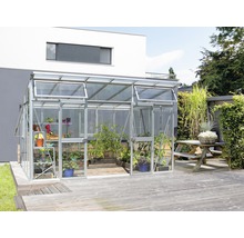 Kas met planten op houten terras voor een woonhuis.