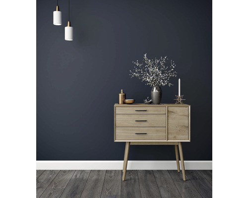 Dressoir met drie laden, decoratie en twee hanglampen voor donkere wand