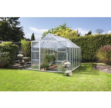 Polycarbonaat kas in tuin met planten.