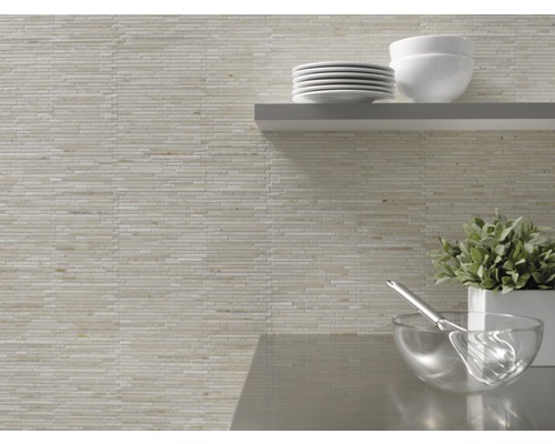 Wanddecoratie met mozaïektegels en keukengerei op een plank.