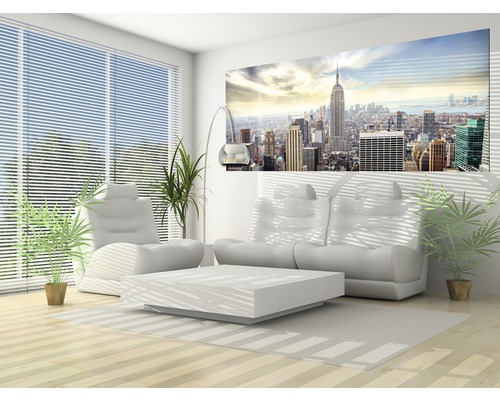 Lichte woonkamer met bank, fauteuil, tafel, kamerplanten en een muurschildering met stadsgezicht