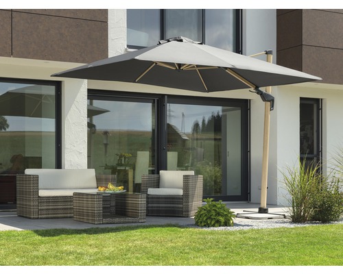 Tuinscene met zweefparasol en rotan zitgroep op een terras