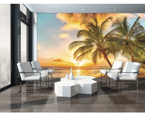 Woonkamer met fotobehang met strandmotief, palmbomen en zonsondergang.