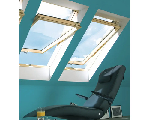 Interieur met dakramen, fauteuil en glas sinaasappelsap