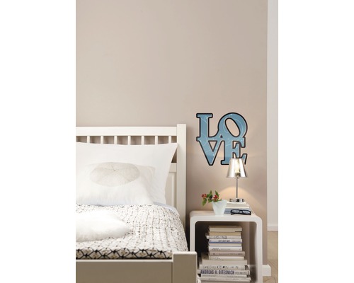 Slaapkamer scène met bed, nachtkastje en decoratieve liefdeslamp aan de muur.