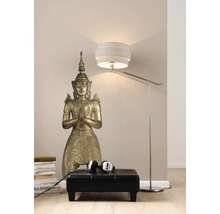 Decoratieve vloerscène met een Boeddhabeeld, een kruk, een stapel boeken, een hoofdtelefoon en een vloerlamp