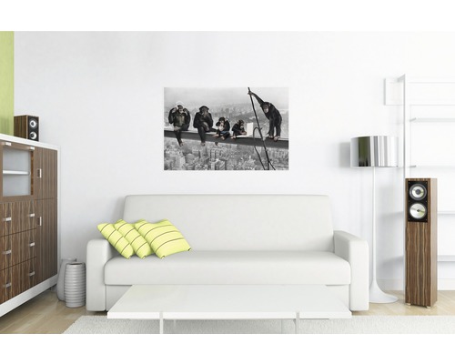 Woonkamer met witte bank en een muurschildering van apen op een hoogbouwsteiger.