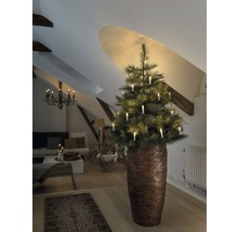 Kerstboom met kaarsen in een woonkamer onder een schuin dak