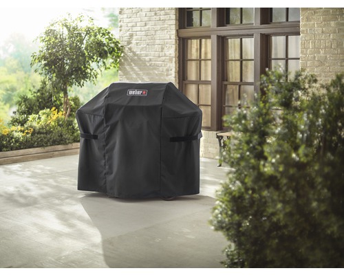 Afgedekte barbecue met Weber logo op een terras