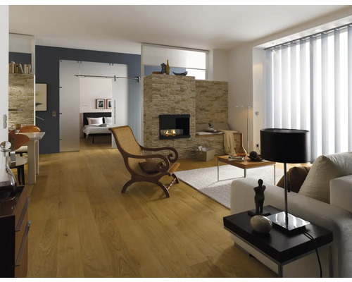 Lichte woonkamer met open haard, houten vloer, bank, stoel en schuifdeur naar de slaapkamer