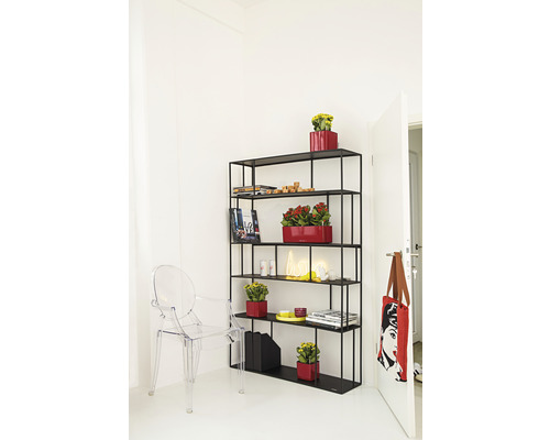 Zwarte boekenkast met vijf planken, versierd met planten in rode potten, tijdschriften, boeken en een neonlamp