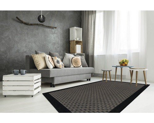 Moderne woonkamer met bank, houten kist als tafel en een vloerkleed met motief