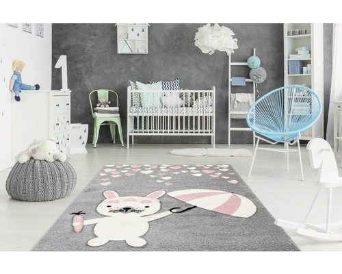 Kinderkamer met grijs tapijt met konijnmotief, kinderbed en meubels