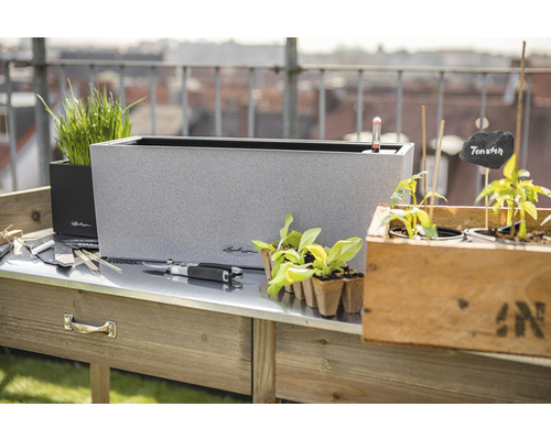 Scene met planttafel, plantenbakken en tuingereedschap voor buiten.