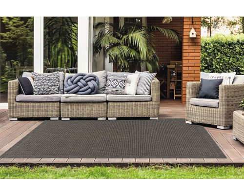 Terras met rotan bankstel en donker tapijt