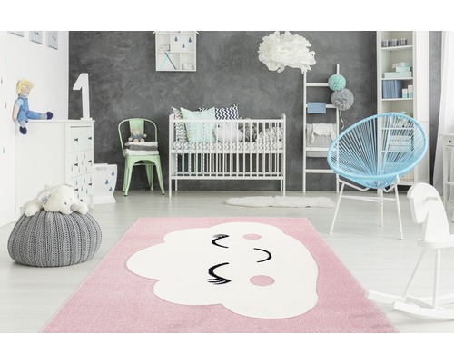 Babykamer met kinderbed, vloerkleed met wolkenmotief en speelgoed