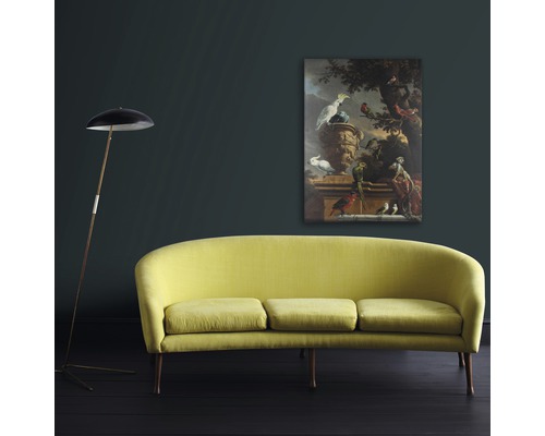 Woonkamer met gele bank, staande lamp en ingelijst schilderij aan de muur