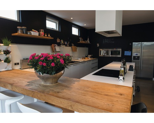 Lichte keuken met houten werkblad, kookeiland, zwarte muren en decoraties