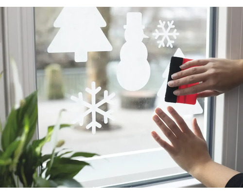 Aanbrengen van raamfolie met wintermotieven met rakel