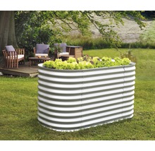 Metalen verhoogde tuinbak in een tuin met slabeplanting