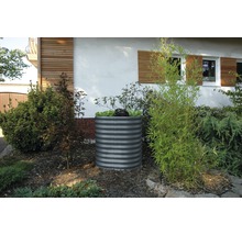 Metalen verhoogde tuinbak in de tuin met beplanting.