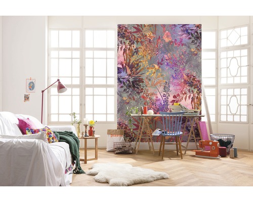 Woonkamer met bloemen fotobehang, bank en werktafel voor een raam