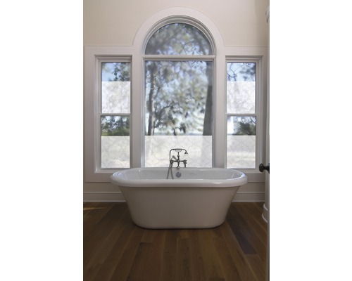 Badkamer met vrijstaand bad en raam met raamfolie