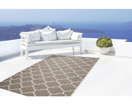 Terras met buitenkleed, bank en potplant met uitzicht op zee