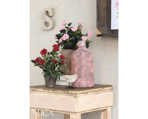 Decoratieve scène met kunstbloemen, vogel en vaas op een tafel