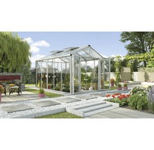 Kas met planten en tuindecoratie in de tuin