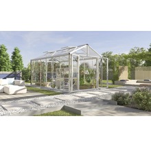 Ruime kas met planten in een tuin met een zithoek