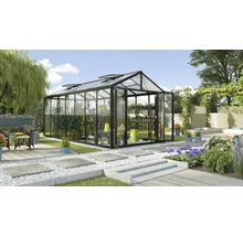 Kas met planten en tuinmeubelen in de tuin