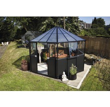 Zeshoekig tuinpaviljoen met tafel en stoelen in een tuin.