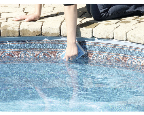 Persoon reinigt een zwembad met een reinigingsspons.