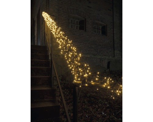 Decoratieve lichtketting langs een trapleuning buitenshuis.