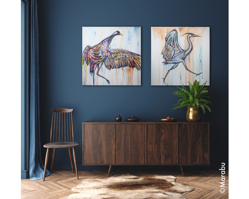 Woonkamer met twee schilderijen van vogels, houten dressoir, stoel en tapijt