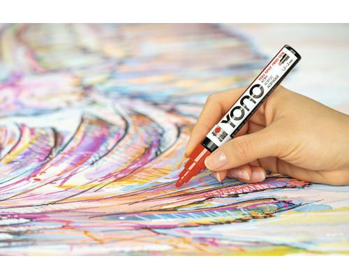 Een hand die met een rode Yono acrylmarker op canvas schildert.