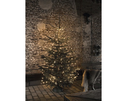 Kerstboom met verlichting voor een bakstenen muur