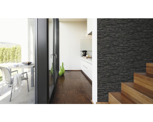 Lichte ruimte met een muur in steenlook, trap en uitzicht op een terras