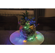 Decoratief plantenarrangement met verlichting in een gevlochten mand op een tafel