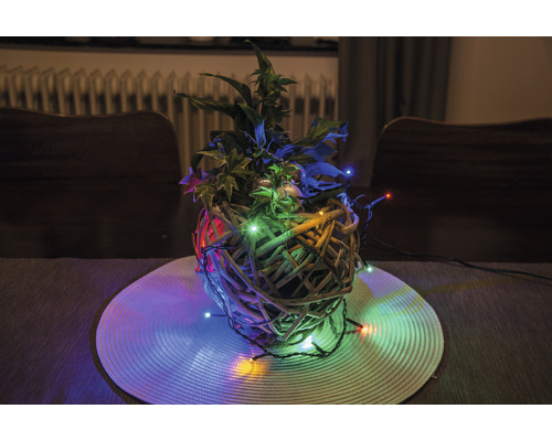Decoratief plantenarrangement met verlichting in een gevlochten mand op een tafel