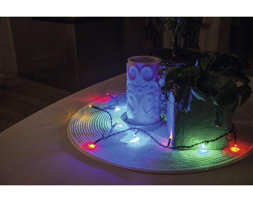 Decoratie met kaars, kamerplanten en lichtsnoer op een tafel